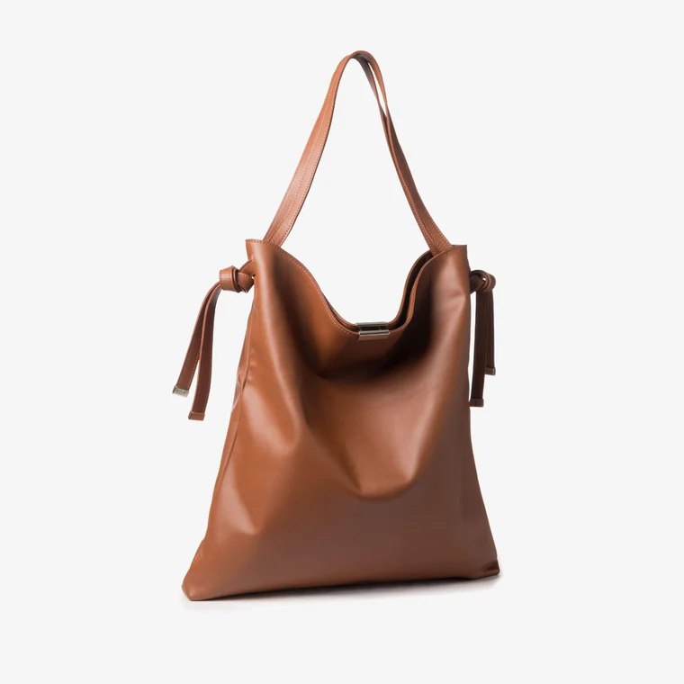 Tan leather shoulder bag with knotted side ties and metal clasp